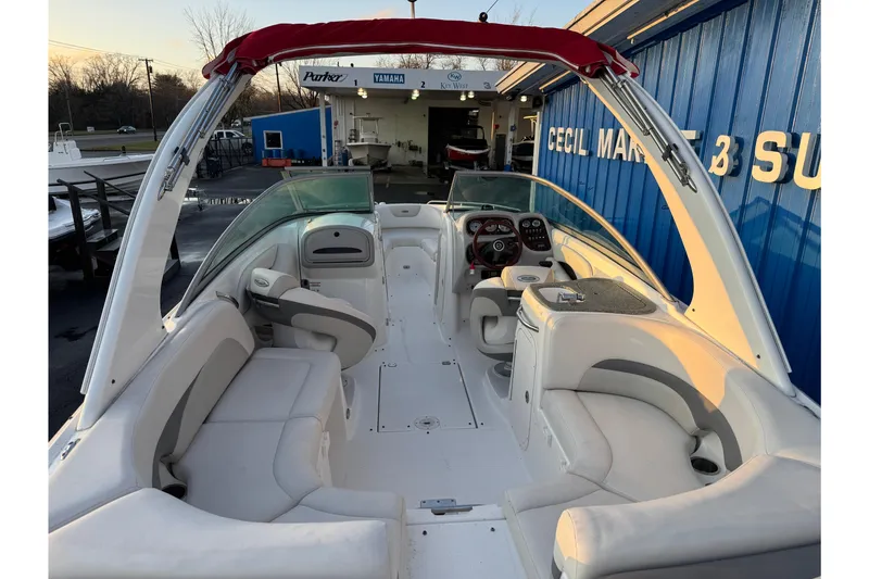 Slide: The Image of 2007 Chaparral 256 SSi boat interior with white seating and red canopy at marina. - 11