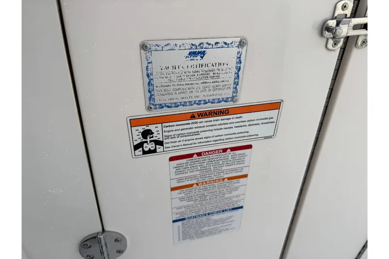 Slide: The Image of 2007 Chaparral 256 SSi warning labels on white surface with metal latch. - 14