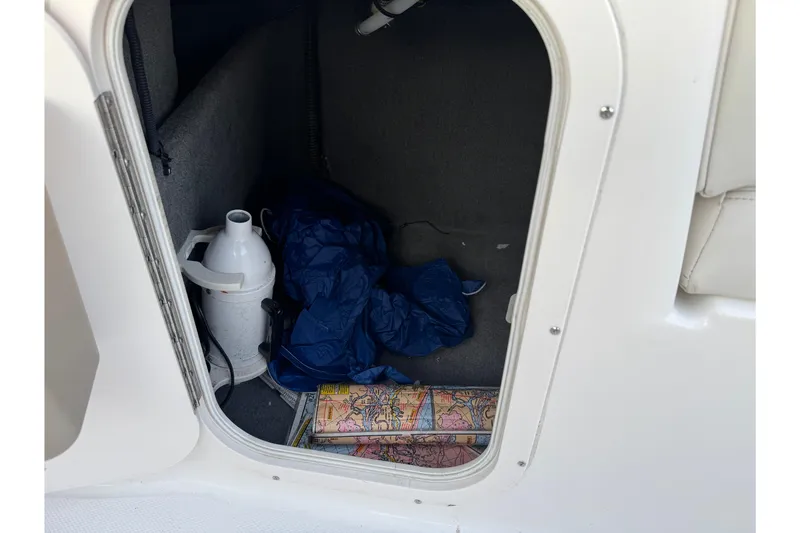 Slide: The Image of Storage compartment in 2007 Chaparral 256 SSi boat with maps and equipment. - 24