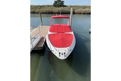 Slide: The Image of 2007 Chaparral 256 SSi boat with red cover docked on calm water. - 46