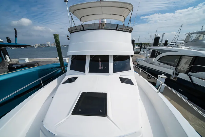 Slide: The Image of 2003 Mainship 390 Trawler docked at marina under clear sky. - 1