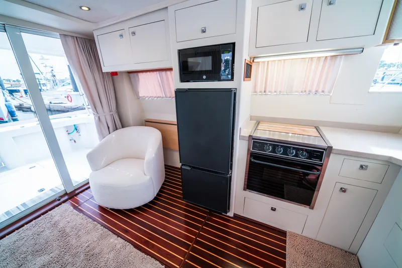 Slide: The Image of Interior of 2003 Mainship 390 Trawler with modern kitchen and cozy seating area. - 11