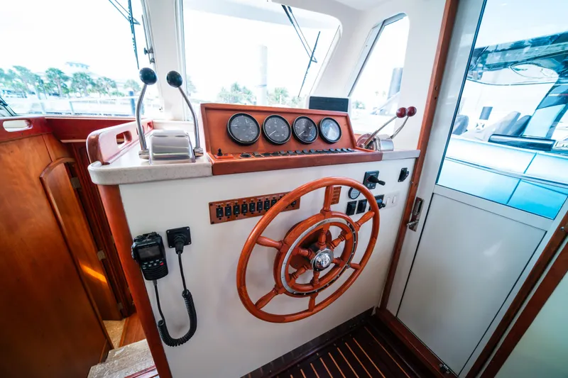 Slide: The Image of 2003 Mainship 390 Trawler helm with wooden wheel and control panel. - 13