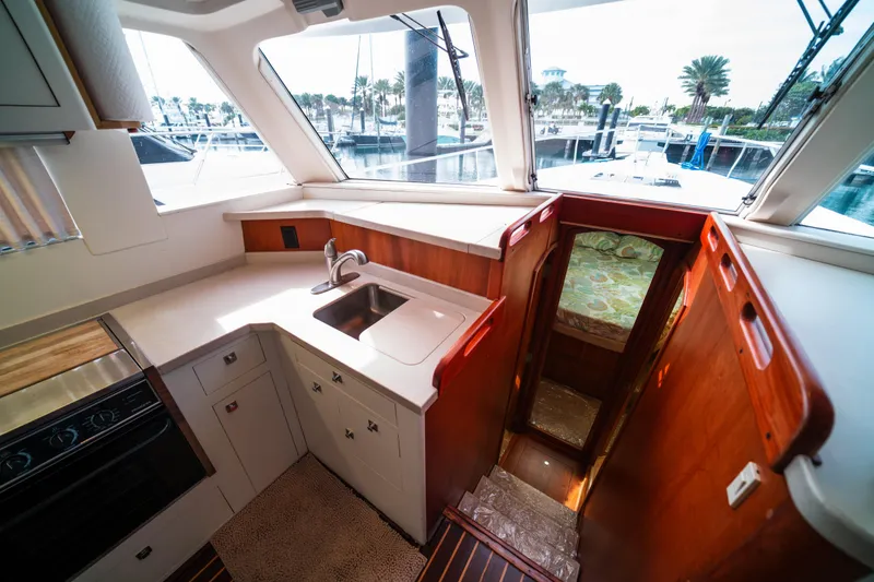 Slide: The Image of 2003 Mainship 390 Trawler interior with kitchen, sink, and cabin access. - 15