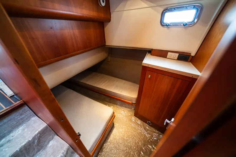 Slide: The Image of 2003 Mainship 390 Trawler cabin with wooden interior and cozy sleeping area. - 16