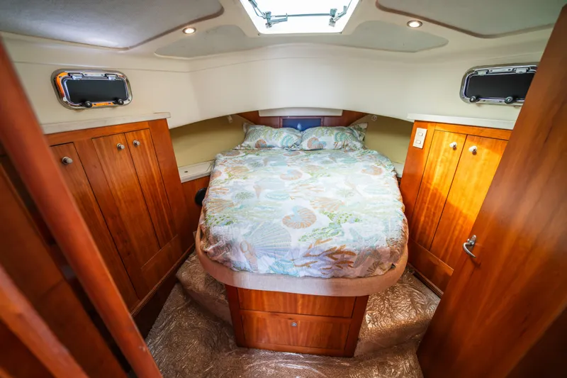Slide: The Image of Cozy cabin interior of 2003 Mainship 390 Trawler with bed and wooden cabinets. - 17