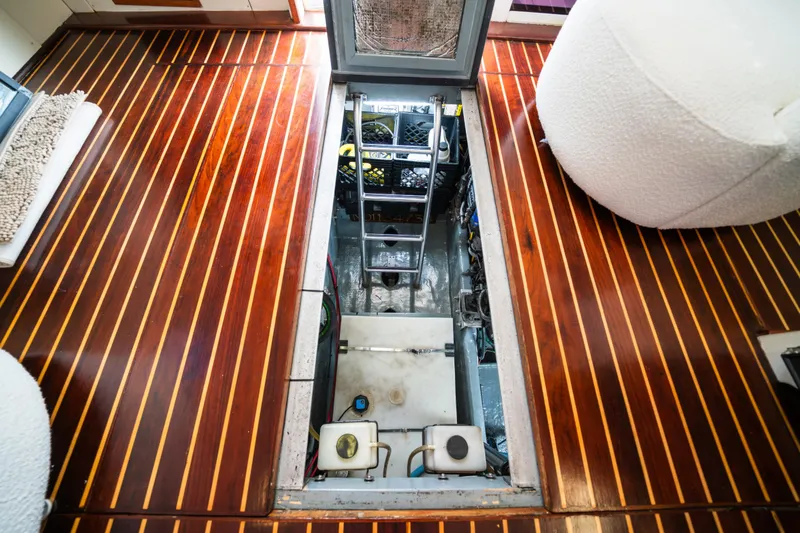 Slide: The Image of Engine compartment of 2003 Mainship 390 Trawler with polished wooden flooring. - 23