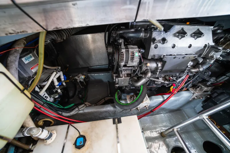 Slide: The Image of Engine room of a 2003 Mainship 390 Trawler, showcasing mechanical components and wiring. - 25