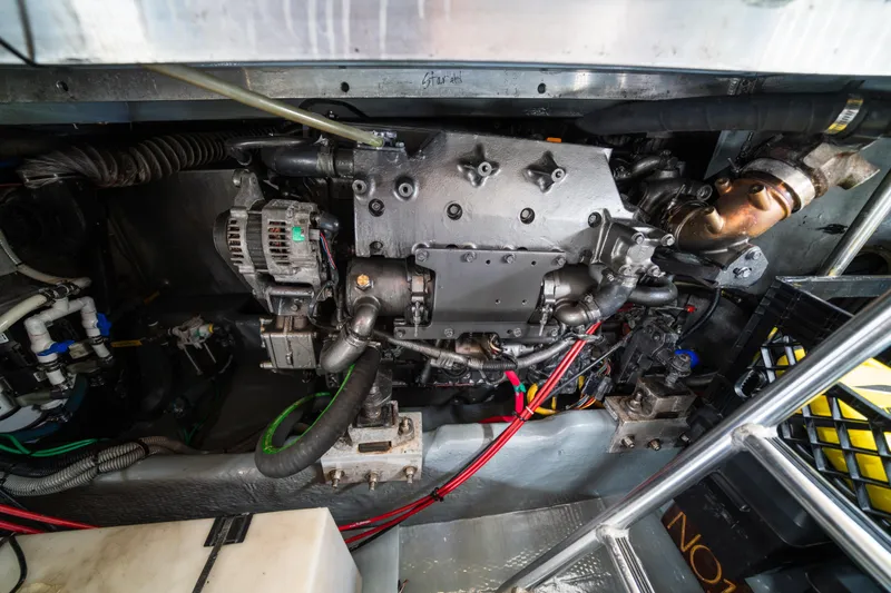 Slide: The Image of Engine room of a 2003 Mainship 390 Trawler, showcasing mechanical components and wiring. - 26