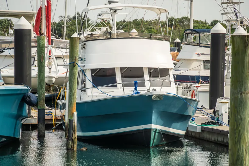 Slide: The Image of 2003 Mainship 390 Trawler docked at a marina, surrounded by other boats. - 30