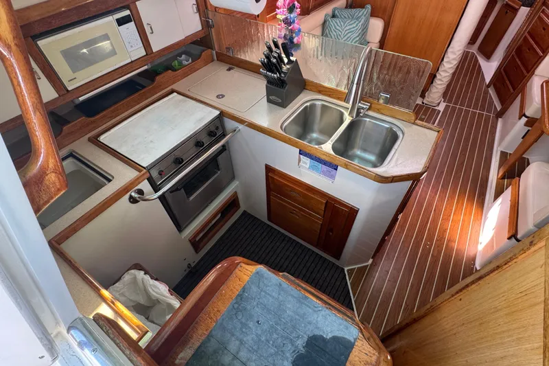 Slide: The Image of Interior of 1997 Catalina 36 MkII sailboat kitchen with stove, sink, and microwave. - 25