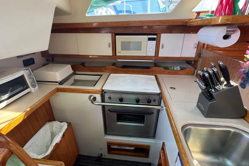 Slide: The Image of 1997 Catalina 36 MkII yacht kitchen with stove, microwave, and sink. - 28