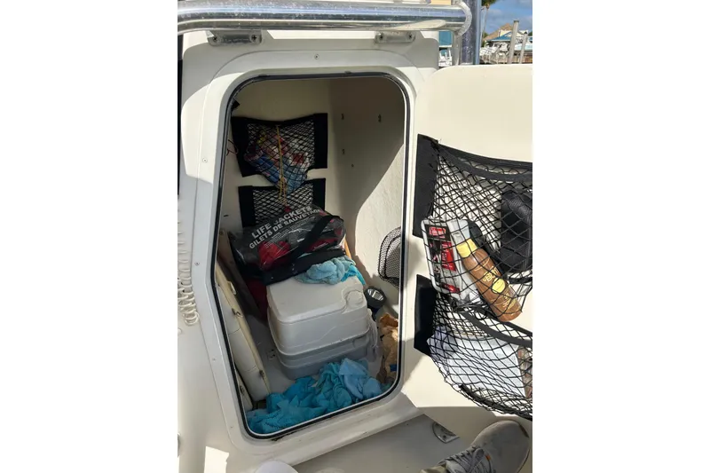 Slide: The Image of 2017 Parker 21SE Center Console storage area with life jackets and supplies. - 8