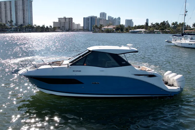 The Image of 2022 Sea Ray Sundancer 320 yacht on sunny waterfront with city skyline. - 1