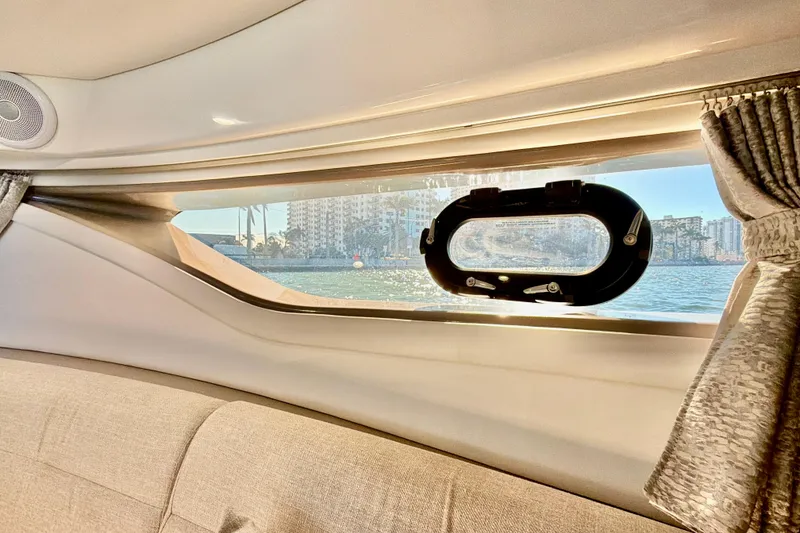Slide: The Image of Interior view of 2022 Sea Ray Sundancer 320 yacht window overlooking water and cityscape. - 12