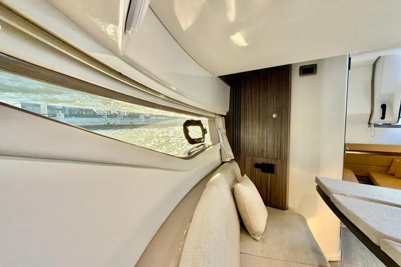 Slide: The Image of Interior of 2022 Sea Ray Sundancer 320 yacht, featuring elegant seating and scenic window view. - 13