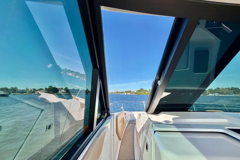 Slide: The Image of 2022 Sea Ray Sundancer 320 yacht with open sunroof, overlooking serene waters. - 17