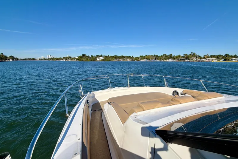 Slide: The Image of 2022 Sea Ray Sundancer 320 cruising on a sunny day, with scenic coastal view. - 18