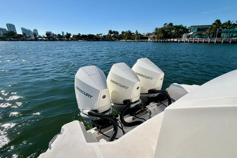 Slide: The Image of 2022 Sea Ray Sundancer 320 with triple Mercury outboard engines on a sunny waterfront. - 33