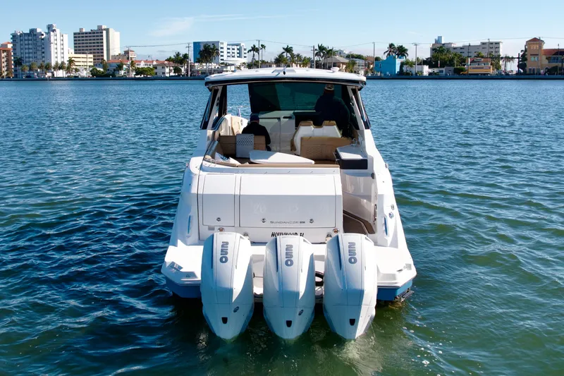 Slide: The Image of 2022 Sea Ray Sundancer 320 boat on water, cityscape in background. - 36