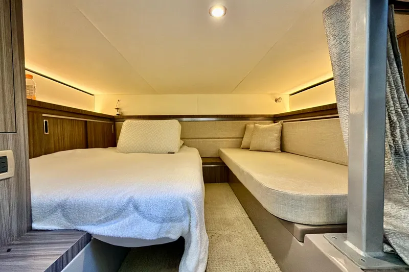 Slide: The Image of 2022 Sea Ray Sundancer 320 cabin interior with cozy bed and seating area. - 5