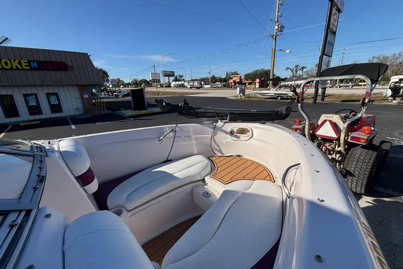 Slide: The Image of 2008 Tahoe Q6 SF boat interior with seating, parked near a store. - 13