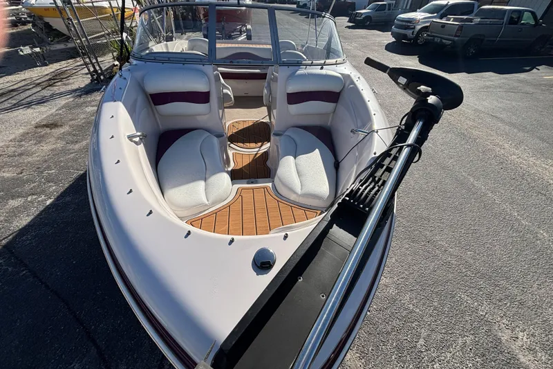 Slide: The Image of 2008 Tahoe Q6 SF boat with white and maroon seating, parked on asphalt. - 5
