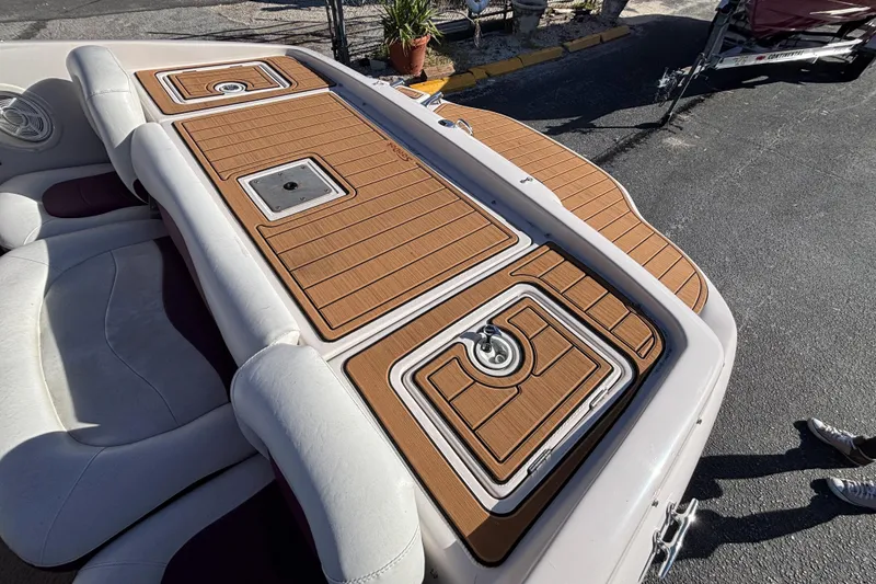 Slide: The Image of 2008 Tahoe Q6 SF boat with tan deck and white seating, parked outdoors. - 6