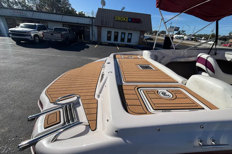 Slide: The Image of 2008 Tahoe Q6 SF boat with wooden deck, parked near a store. - 9