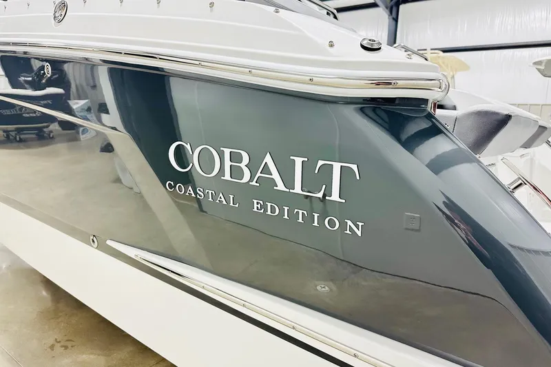 Slide: The Image of 2026 Cobalt R6 Outboard Coastal Edition boat in showroom, side view. - 14