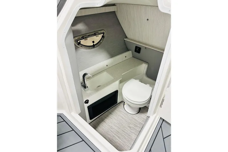 Slide: The Image of 2026 Cobalt R6 Outboard boat interior with compact bathroom, featuring a toilet and sink. - 6
