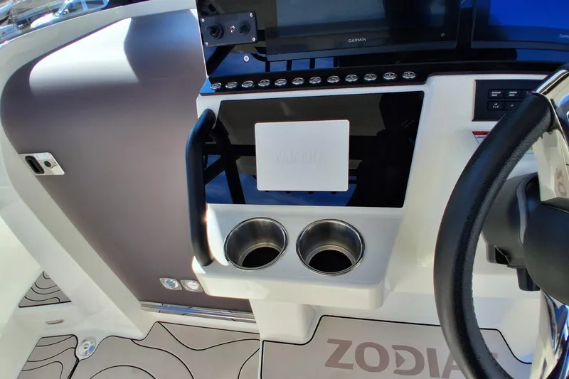 Slide: The Image of Control panel of 2027 Zodiac X10CC boat with steering wheel and cup holders. - 11