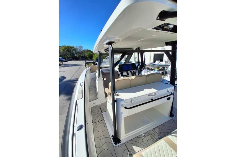 Slide: The Image of 2027 Zodiac X10CC boat interior with modern console and seating, docked under clear blue sky. - 6