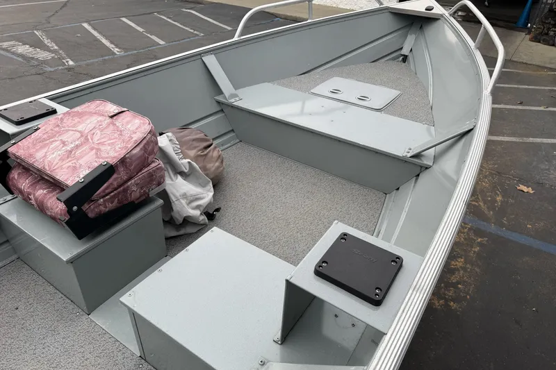 Slide: The Image of 2023 Klamath 14 Deluxe boat interior with pink seat cushions and storage compartments. - 10