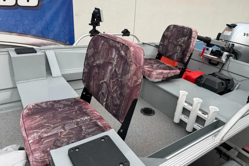 Slide: The Image of 2023 Klamath 14 Deluxe boat interior with camo seats and fishing rod holders. - 11