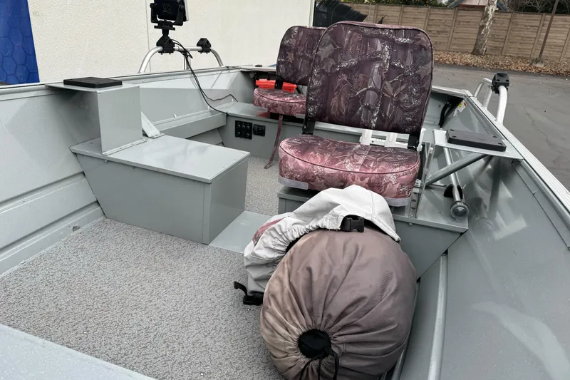 Slide: The Image of 2023 Klamath 14 Deluxe boat interior with camo seats and gear bag. - 12