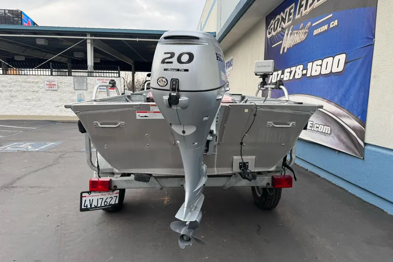 Slide: The Image of 2023 Klamath 14 Deluxe boat with 20 HP outboard motor in parking lot. - 5