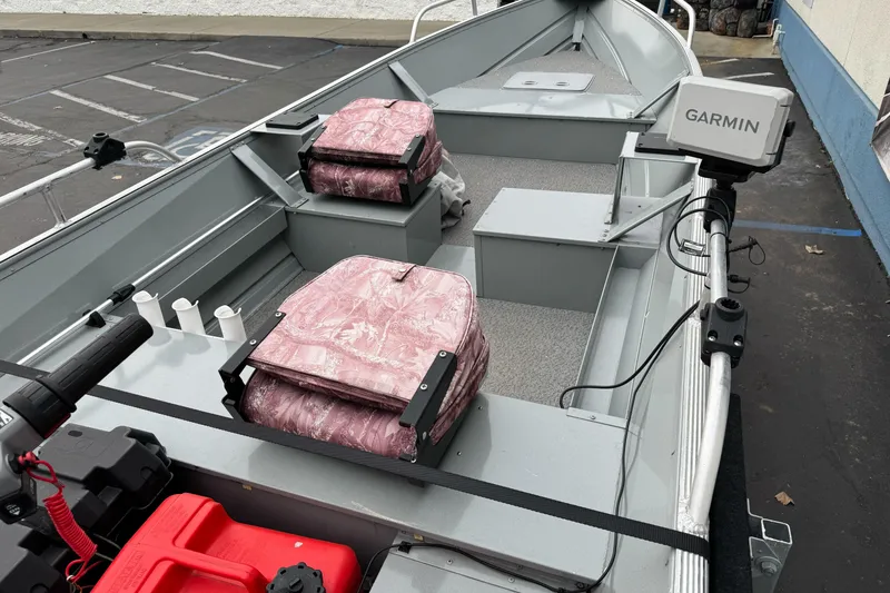 Slide: The Image of 2023 Klamath 14 Deluxe boat interior with pink seats and Garmin equipment. - 7
