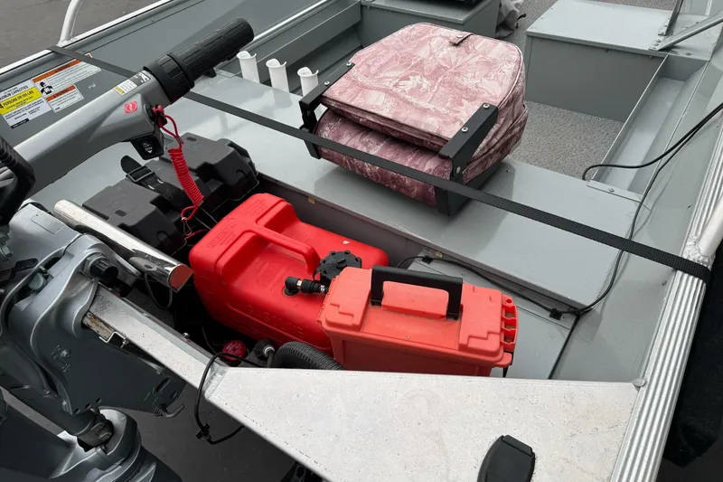 Slide: The Image of 2023 Klamath 14 Deluxe boat interior with motor, fuel tank, and storage. - 8