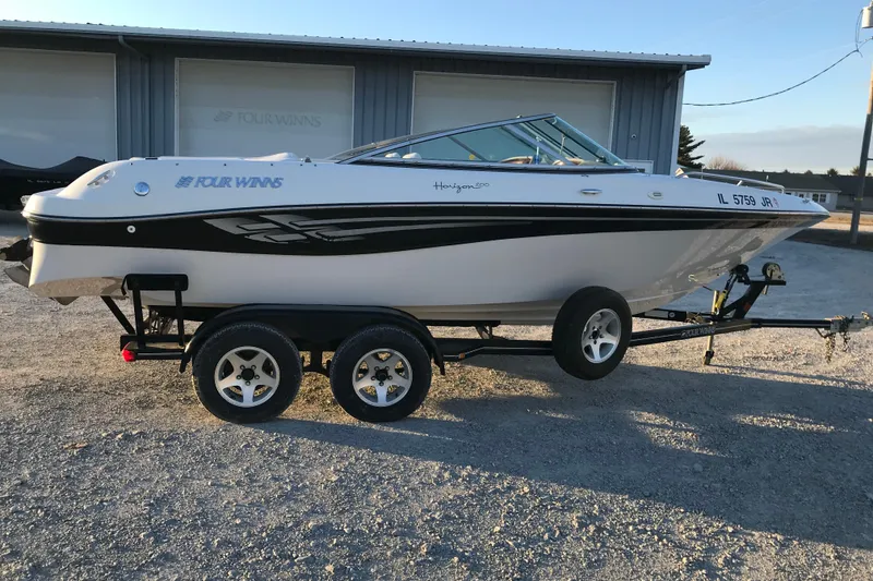 The Image of 2001 Four Winns 200 Horizon boat on trailer, parked outdoors. - 1