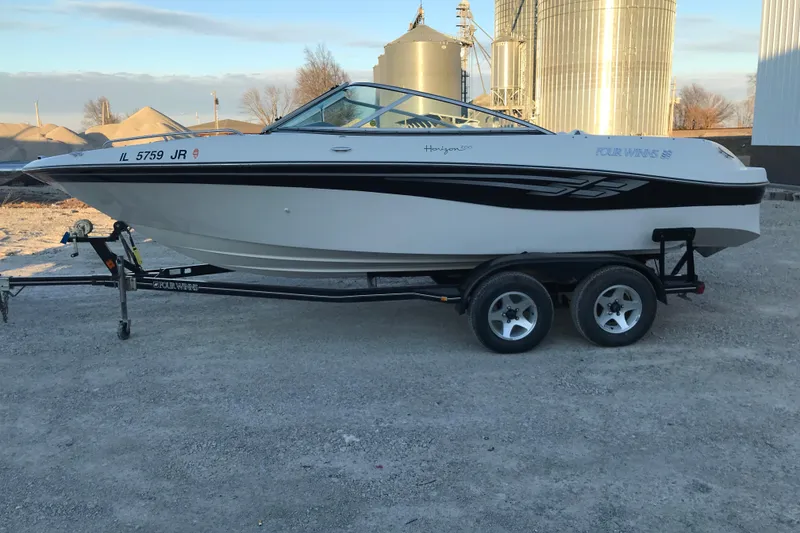 Slide: The Image of 2001 Four Winns 200 Horizon boat on trailer, parked outdoors near industrial silos. - 14