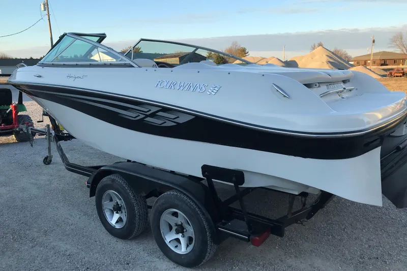 Slide: The Image of 2001 Four Winns 200 Horizon boat on trailer, white with black accents, parked outdoors. - 15