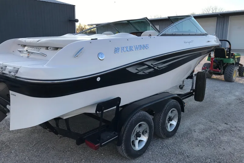 Slide: The Image of 2001 Four Winns 200 Horizon boat on trailer, white with black accents, parked outdoors. - 17