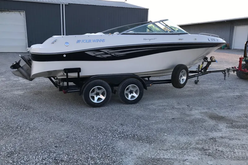 Slide: The Image of 2001 Four Winns 200 Horizon boat on trailer, parked outdoors near a building. - 18