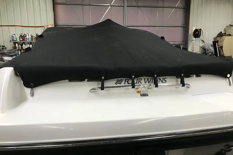 Slide: The Image of 2001 Four Winns 200 Horizon boat with black cover in a garage setting. - 24