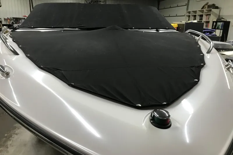 Slide: The Image of 2001 Four Winns 200 Horizon boat with black cover in a garage setting. - 25