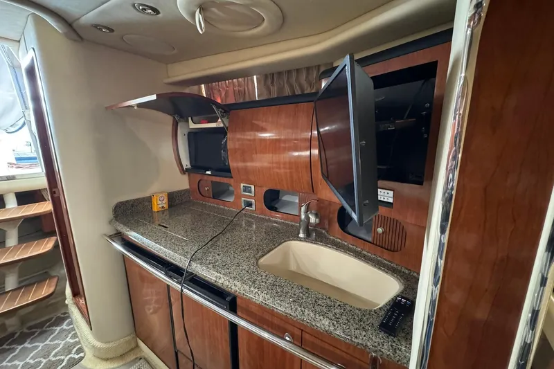 Slide: The Image of 2005 Sea Ray 360 Sundancer interior with modern kitchen and entertainment setup. - 12