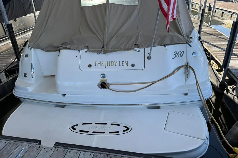 Slide: The Image of 2005 Sea Ray 360 Sundancer docked, rear view with cover and American flag. - 2
