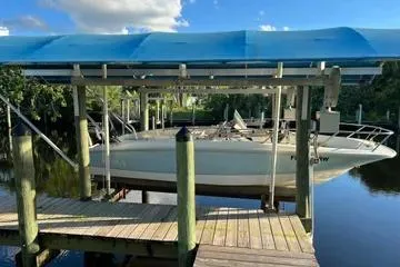 Slide: The Image of 2018 Boston Whaler 170 Super Sport boat docked under blue canopy. - 4