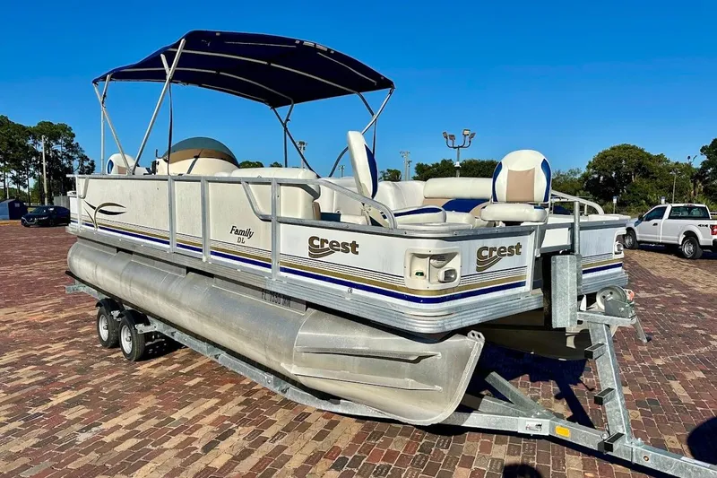 The Image of 2004 Crest 2200 Family DL pontoon boat on trailer, parked on brick pavement. - 1